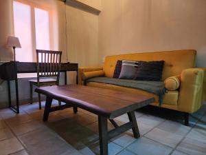 a living room with a couch and a table and a chair at The Urban Nest - Cozy Studio with AC in San Miguel de Allende