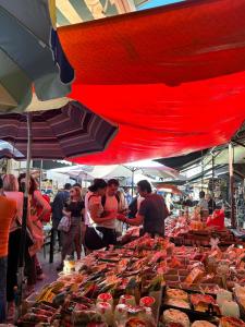 a group of people standing around a market with food at Sweet dreams in Palermo