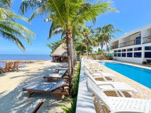 a resort with a row of chairs and a swimming pool at Hotel Costa Linda in Tolú