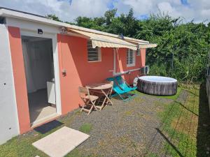 a small house with a table and chairs in the yard at Appartement Bleu Corail avec Jacuzzi in Les Trois-Îlets +4 photos