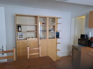 a kitchen with a table and a wooden book shelf at Casa Danieli 1 in Bechtolsheim