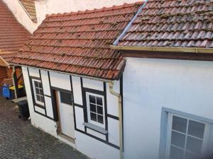 a white and black building with a red roof at Casa Danieli 1 in Bechtolsheim