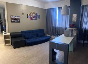 a living room with a blue couch and a table at FLAT NO CORAÇÃO De ALPHAVILLE in Barueri