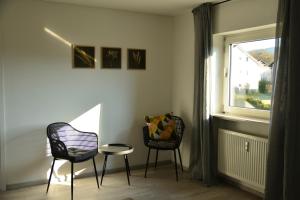 two chairs and a table in a room with a window at Ferienwohnung Taubersonne in Igersheim