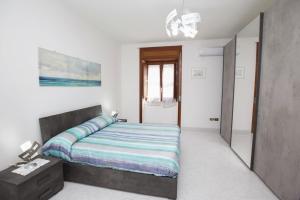 una camera da letto con un letto grande in una stanza bianca di La Dea del mare a Maiori