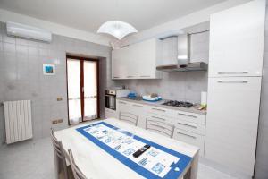 una cucina con armadi bianchi e un tavolo di La Dea del mare a Maiori