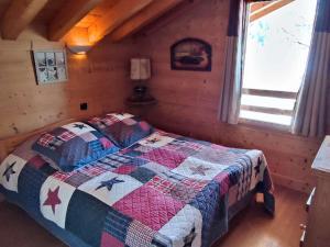 イゾラにあるCharmant chalet à Isola 2000 avec cheminée - FR-1-292-224のベッドルーム(キルト付きのベッド付)
