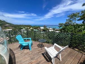 two chairs and a table on a deck with the ocean at Maharepa Lodges Vue sur les étoiles in Maharepa