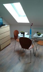 a room with a table and chairs and a skylight at Apartment Olomouc in Olomouc