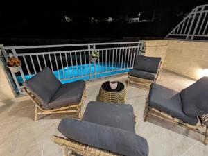 a patio with chairs and a swimming pool at night at Hal Wardija Sunny Retreat in Qala