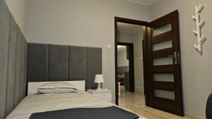 a bedroom with a bed with a large padded headboard at Jedenastka in Płock +7 photos