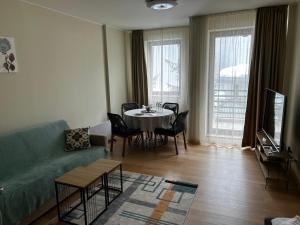 a living room with a couch and a table with chairs at Silent retreat at Euphoria Club and SPA Borovets in Borovets