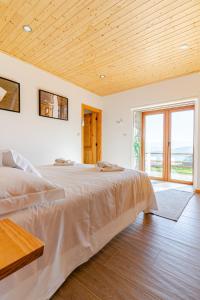 a bedroom with a large bed with a wooden ceiling at CASA DO SOL , Turismo Rural in Celorico de Basto +57 photos