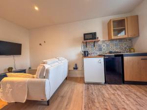 a living room with a white couch and a kitchen at Appartment la Petite Bleu in Pessac