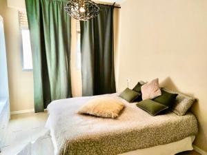 アルカラ・デ・グアダイラにあるHappy Sevillaのベッドルーム1室(緑のカーテンとシャンデリア付きのベッド1台付) +26枚の写真