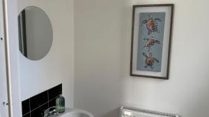 La salle de bains est pourvue d'un lavabo et d'une photo murale. dans l'établissement The cozy, à Bristol