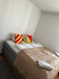 a bed with two colorful pillows on it in a room at Helsinki Sweet Homes in Helsinki