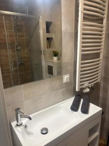 a bathroom sink with a mirror and a shower at Apartament Nova Starówka in Konin +17 photos