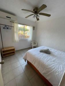 una camera da letto con un letto e un ventilatore a soffitto di Condominio Flamingos a Ixtapa