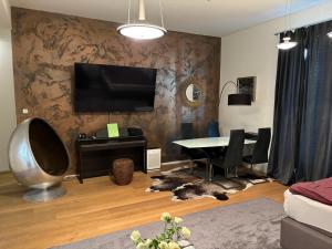 a living room with a table and a television on a wall at 2 Rooms Shanghaiallee Appartment in Hamburg
