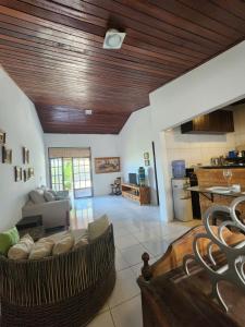 un salon avec un canapé et une cuisine dans l'établissement Casa de Praia - Ilha da Crôa - Barra de Sto Antônio, à Barra de Santo Antônio