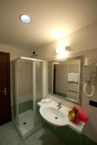 y baño con lavabo y ducha. en Hotel Roma en Cassano Magnago