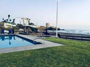 a swimming pool next to a beach with the ocean at Beachfront Boutique Villa Cazadores in Rosarito