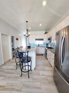 a kitchen with a table and a stainless steel refrigerator at Beachfront Boutique Villa Cazadores in Rosarito