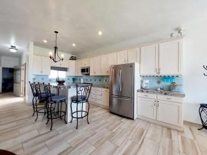 a kitchen with white cabinets and a stainless steel refrigerator at Beachfront Boutique Villa Cazadores in Rosarito +47 photos