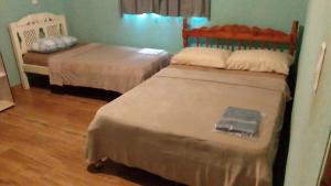 zwei Betten in einem Zimmer mit Holzboden in der Unterkunft casa in Rio Verde + 21 Fotos