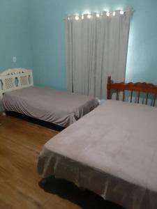 ein Schlafzimmer mit zwei Betten und einem Fenster mit Vorhängen in der Unterkunft casa in Rio Verde