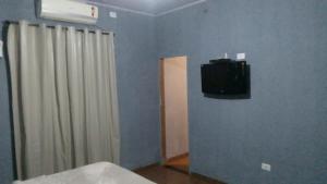 Zimmer mit einem TV an einer Wand mit einem Vorhang in der Unterkunft casa in Rio Verde