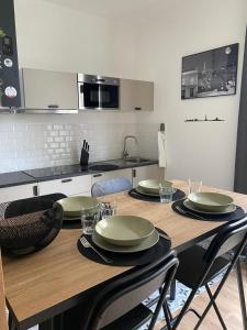 une cuisine avec une table en bois et des plaques de cuisson. dans l'établissement charmant 2 pièces, à Cormeilles-en-Parisis