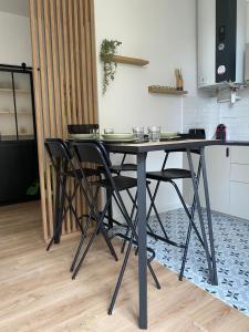 - une table à manger avec des chaises noires dans la cuisine dans l'établissement charmant 2 pièces, à Cormeilles-en-Parisis 3 autres photos