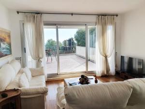 a living room with a white couch and a sliding glass door at Luxury Duplex with Sea View in Sant Pere de Ribes