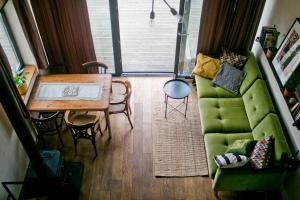 a living room with a green couch and a table at Powoli - wyjątkowy domek w Izerach in Wolimierz