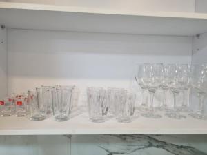 a row of wine glasses sitting on a shelf at kikar natanya in Netanya +6 photos