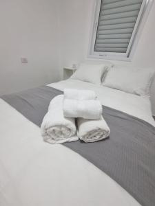 een slaapkamer met witte handdoeken op een bed bij kikar natanya in Netanya +6 foto's