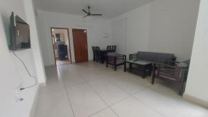 a living room with a couch and a table and chairs at Orange valley Residency Thodupuzha in Thodupuzha