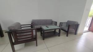 a living room with a couch and two chairs and a table at Orange valley Residency Thodupuzha in Thodupuzha