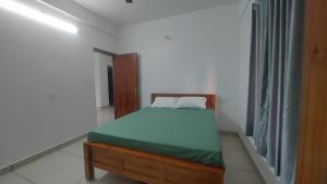 a bedroom with a bed in a white room at Orange valley Residency Thodupuzha in Thodupuzha +2 photos