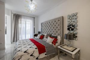 a bedroom with a large bed and a chandelier at Villa Berfami - Managed by Excelsior Villas in Podstrana