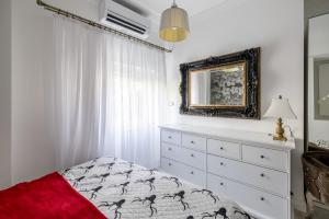 a bedroom with a bed and a dresser with a mirror at Villa Berfami - Managed by Excelsior Villas in Podstrana