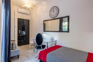 a bedroom with a desk and a clock on the wall at Villa Berfami - Managed by Excelsior Villas in Podstrana