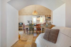 un soggiorno e una sala da pranzo con tavolo e sedie di Apulia Trulli Macco Macco Locorotondo a Locorotondo Altre 5 foto