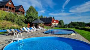 波拉齐克Na Górce - Domki z Widokiem Na Jezioro i Góry的庭院中的游泳池,带椅子和房子