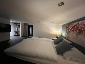 a bedroom with a large white bed with a painting on the wall at Premium-Strand Chalet an der Nordsee - Noordzee - Zeeland in Breskens +31 photos