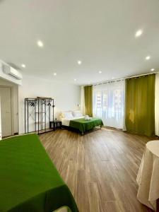 Habitación grande con 2 camas y manta verde. en Galka Rooms, en Palermo