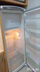 an empty refrigerator with its door open at Everest Flat Conforto, Lazer e Localização Central in Caldas Novas