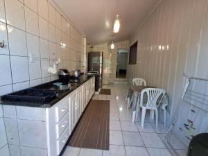 a kitchen with a counter and a table in a room at Casa de Praia 3 Dormitórios Imbituba Santa Catarina in Imbituba